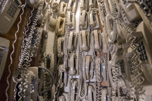 old cable telephones hanging from the wall photo
