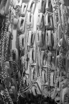 old cable telephones hanging from the wall photo