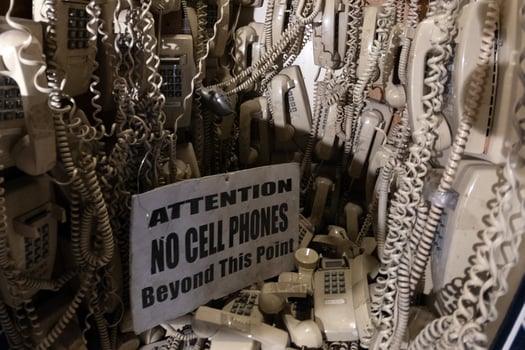 old cable telephones hanging from the wall photo