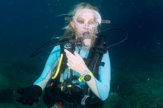 beautiful girl looking at you while swimming underwater photo