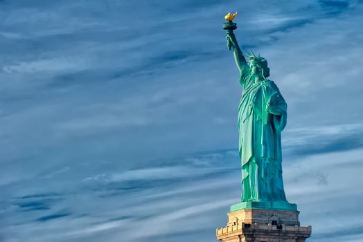 Statue of liberty close up vertical isolated in blue cloudy background photo