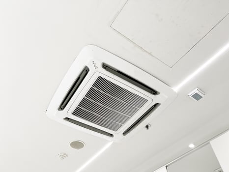 Ceiling mounted cassette type air conditioner and modern lamp light on white ceiling. duct air conditioner for home or office photo