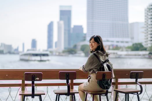 Young Asian woman backpack traveler waiting an express boat at pier on Chao Phraya River in Bangkok. Journey trip lifestyle, world travel explorer or Asia summer tourism concept photo