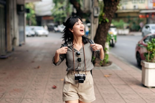 Young Asian woman backpack traveler enjoying street cultural local place and smile. Traveler checking out side streets. photo