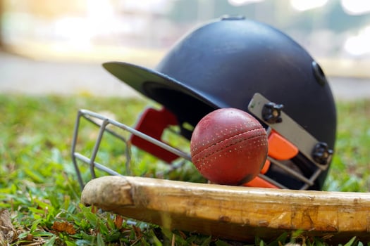 Cricket equipment is a cricket ball, cricket bat, cricket helmet on a grass background. Soft and selective focus. photo