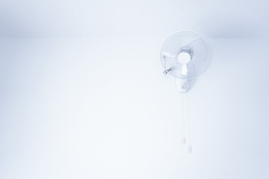 Wall mount electric white fan,electric fan hanging on white mortar wall photo