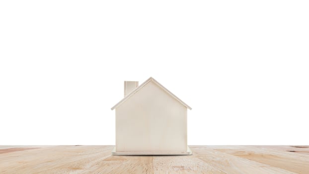 Small home model on wooden table isolated on white background.Family life and Business real estate concept. photo
