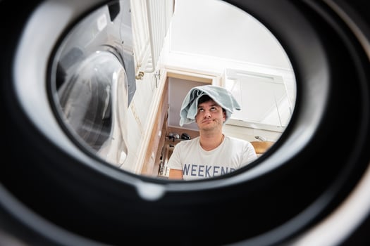 Man view from washing machine inside. Male does laundry daily routine. photo