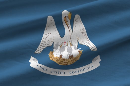 Louisiana US state flag with big folds waving close up under the studio light indoors. The official symbols and colors in banner photo