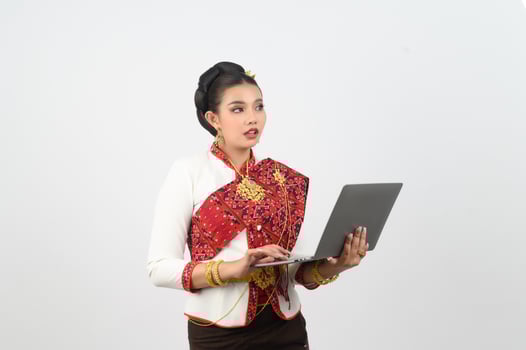 Portrait of Beautiful Thai Woman in Traditional Clothing Posing with laptop computer photo