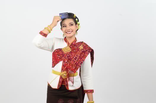 Portrait of Beautiful Thai Woman in Traditional Clothing Posing with credit card photo