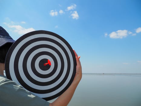 young business woman carrying success goals the concept of business There is a red dart in the center of the target. photo
