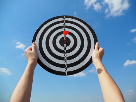 hand of a business woman holding a target business success business idea red dart in the center up in the sky photo