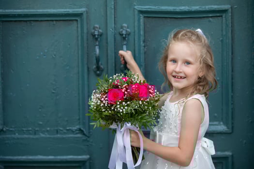 A cute little girl is holding a bouquet of flowers. Women's Day. little girl and flower. Happy child on holiday with flowers. photo