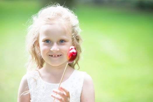 Little girl holding a small red heart. Child with a toy heart. photo
