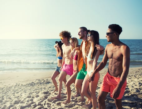 Group of happy friends having fun at ocean beach photo