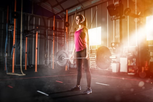 Athletic girl works out at the gym with a barbell photo