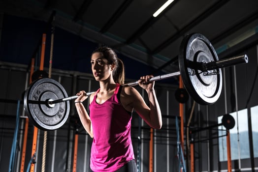 Athletic girl works out at the gym with a barbell photo