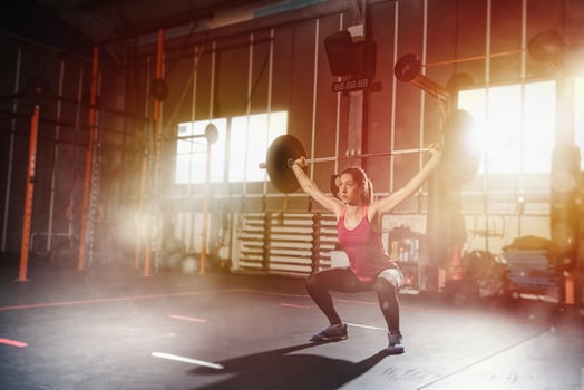 Athletic girl works out at the gym with a barbell photo