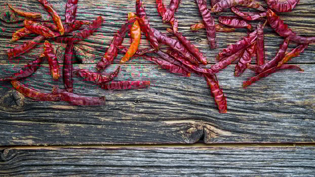 Dry spicy red pepper on rustic wooden background from above with copy space photo