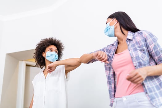 Elbow bump. New novel greeting to avoid the spread of coronavirus. Two women friends meet with bare hands. Instead of greeting with a hug or handshake, they bump elbows instead. photo