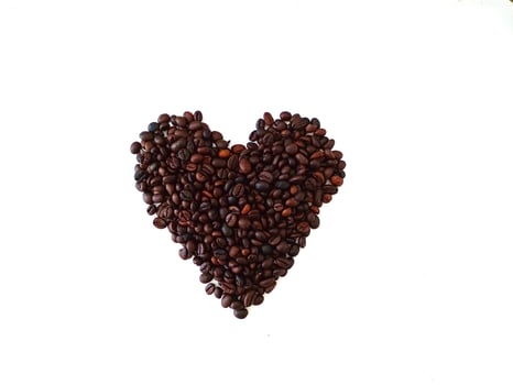Heath shaped soap bar on coffee beans close up isolated on white background photo