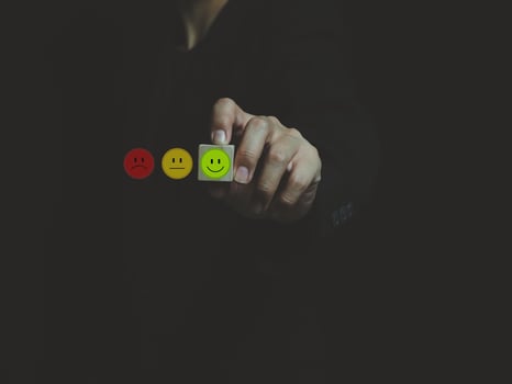 green smiley satisfaction expression icon in the wooden block on the hand of a businessman expression of satisfaction photo