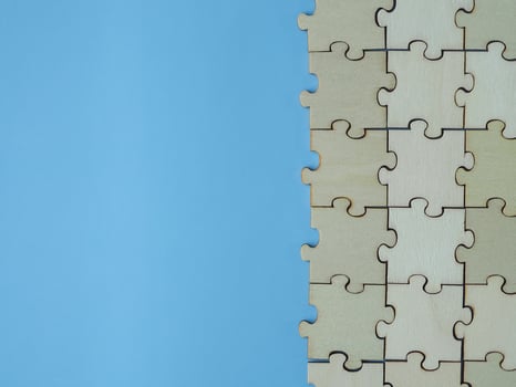 Complete wooden jigsaw puzzles business cooperation on a blue background photo