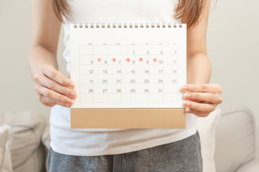 Menstruation, periods cycle day of monthly, hurt asian young woman, female hand holding, marking symbol on calendar for missed and delay or late. Medical, healthcare, gynecological concept. Copy space photo