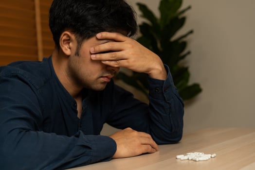 Stressed, sad asian young man, male abuse overdose pills and addict, take medicine. Sick pain of health treatment, unhappy people. Suicide depressed or despair. photo