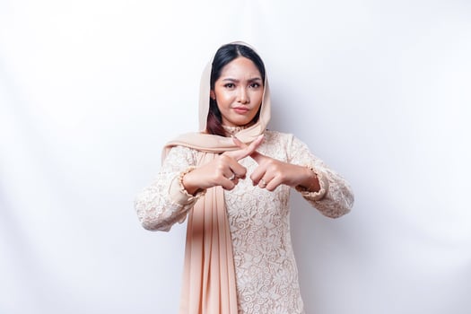 Beautiful Asian Muslim woman wearing a hijab with hand gesture pose rejection or prohibition with copy space photo
