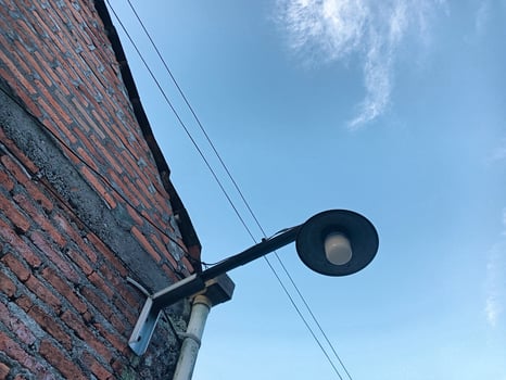 Street lamp next to brick wall with blue sky photo