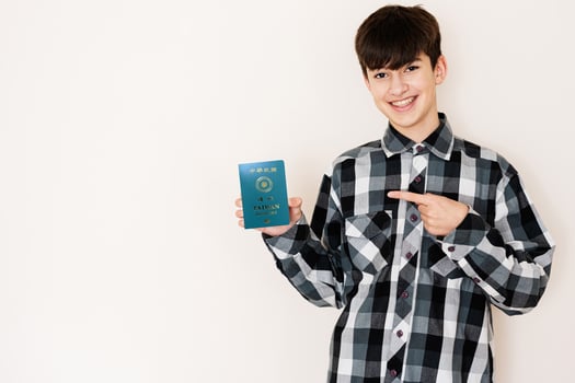 Young teenager boy holding Taiwan passport looking positive and happy standing and smiling with a confident smile against white background. photo