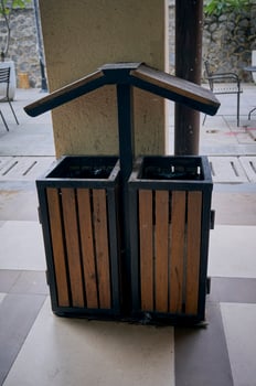 Single rubbish bin, garbage and waste bin made of wooden material. A garbage collection tank in the corner of building. A clean container for household waste.  Wooden waste boxes or trash bin. photo
