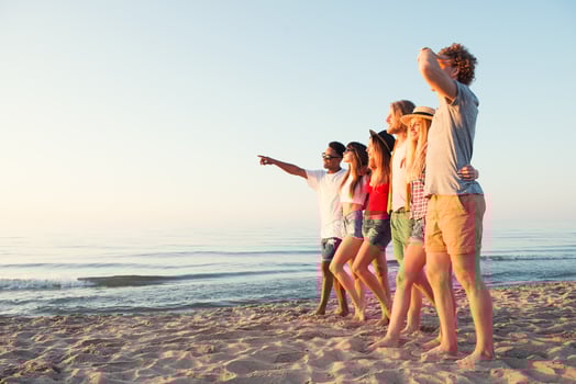 Group of happy friends having fun at ocean beach photo