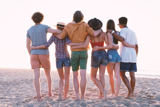 Group of happy friends having fun at ocean beach photo