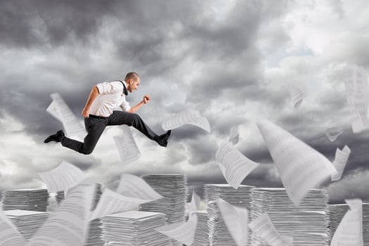 Businessman runs away from the worksheets and bureaucracy photo