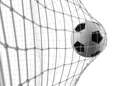 Soccer ball scores a goal on the net in a football match photo
