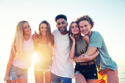 Group of happy friends having fun at ocean beach at dawn photo