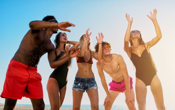 Group of friends playing at beach volley at the beach photo