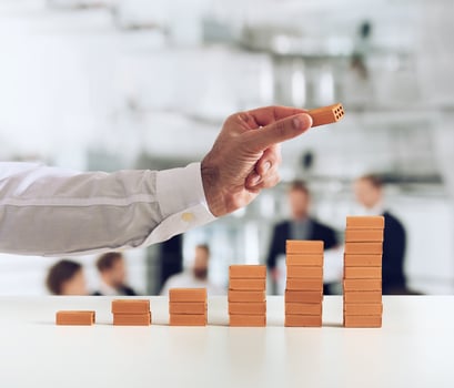 Businessman puts a brick on a bricks pile. Concept of growing statistics and success photo