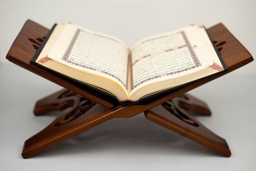 Open holy Quran on traditional wooden table photo