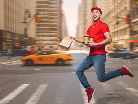 Delivery guy dressed in red runs to deliver the ordered drinks photo