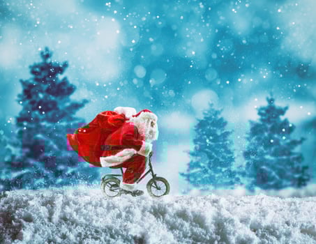 Santa Claus on a little bike on a winter landscape under the snow photo