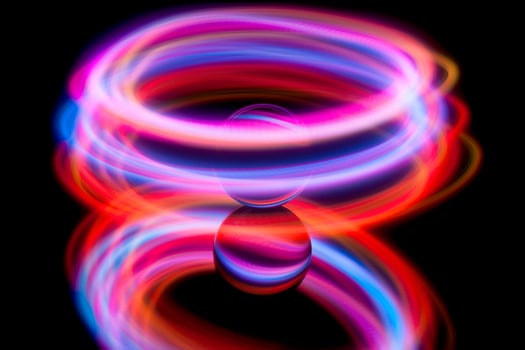 Abstract light painting circling around a glass ball photo