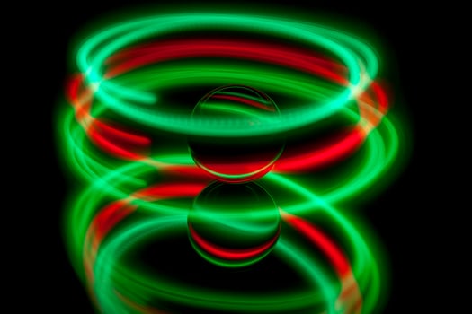 Abstract light painting circling around a glass ball photo
