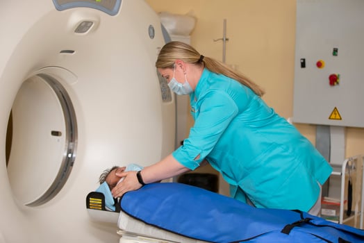 A doctor in a medical gown prepares a patient for magnetic resonance imaging MRI computed tomography in a hospital. photo