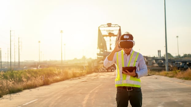 Asian engineer using virtual reality headset and tablet for inspecting and working at construction site photo
