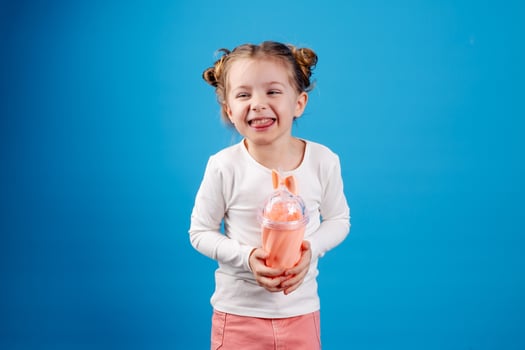 portrait of a small happy girl of Slavic appearance drinking a cocktail of berries. place for text photo