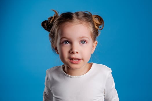 portrait of a small happy girl of Slavic appearance on a blue background. place for text photo